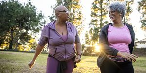 dvije crne žene koje hodaju travnatim poljem